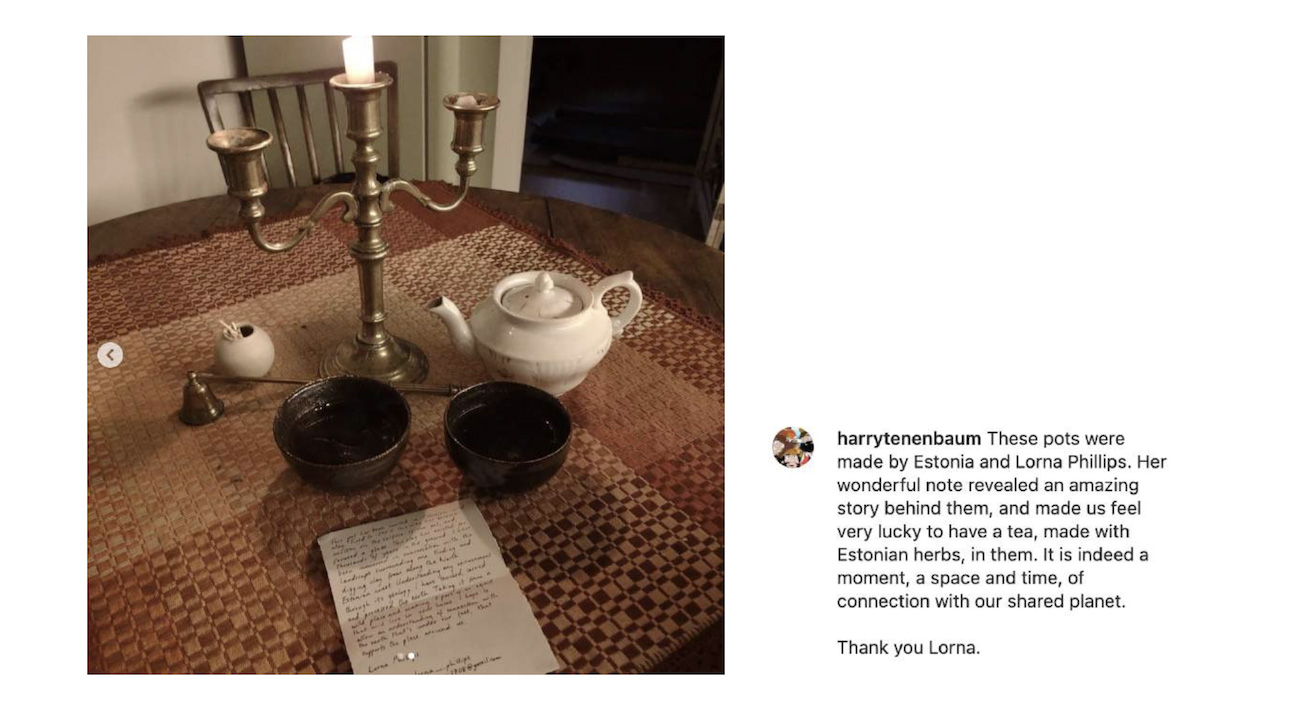 Two tea bowls, a teapot and a note on a table.