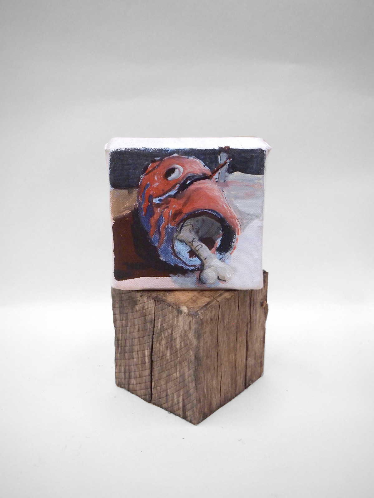 Photo of a painting showing a bone laying in a helmet atop a wooden cube