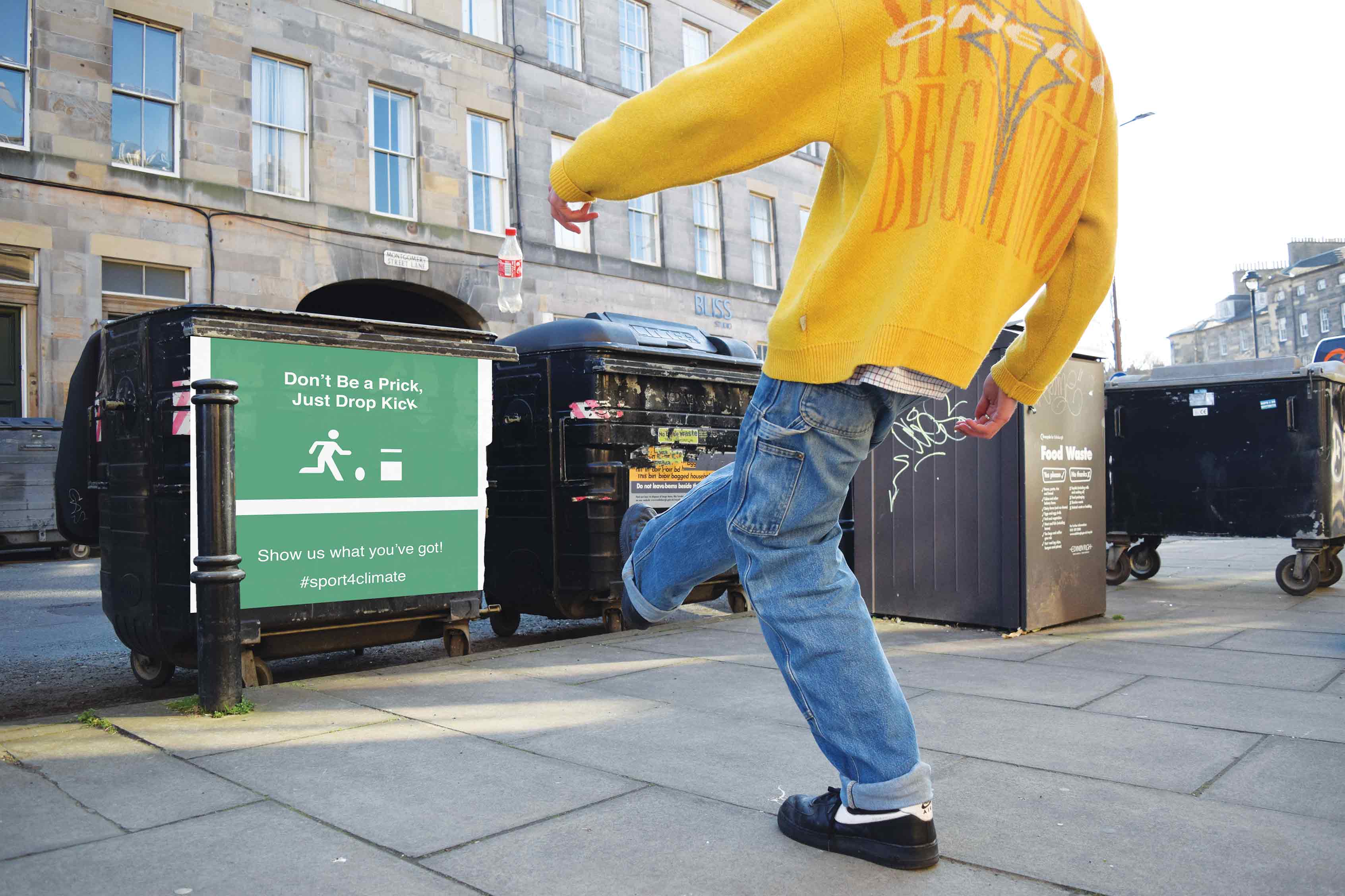 Kicking a plastic bottle into a bin.