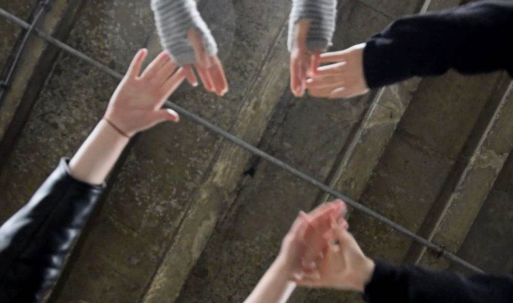 Six hands reaching out and coming together to join