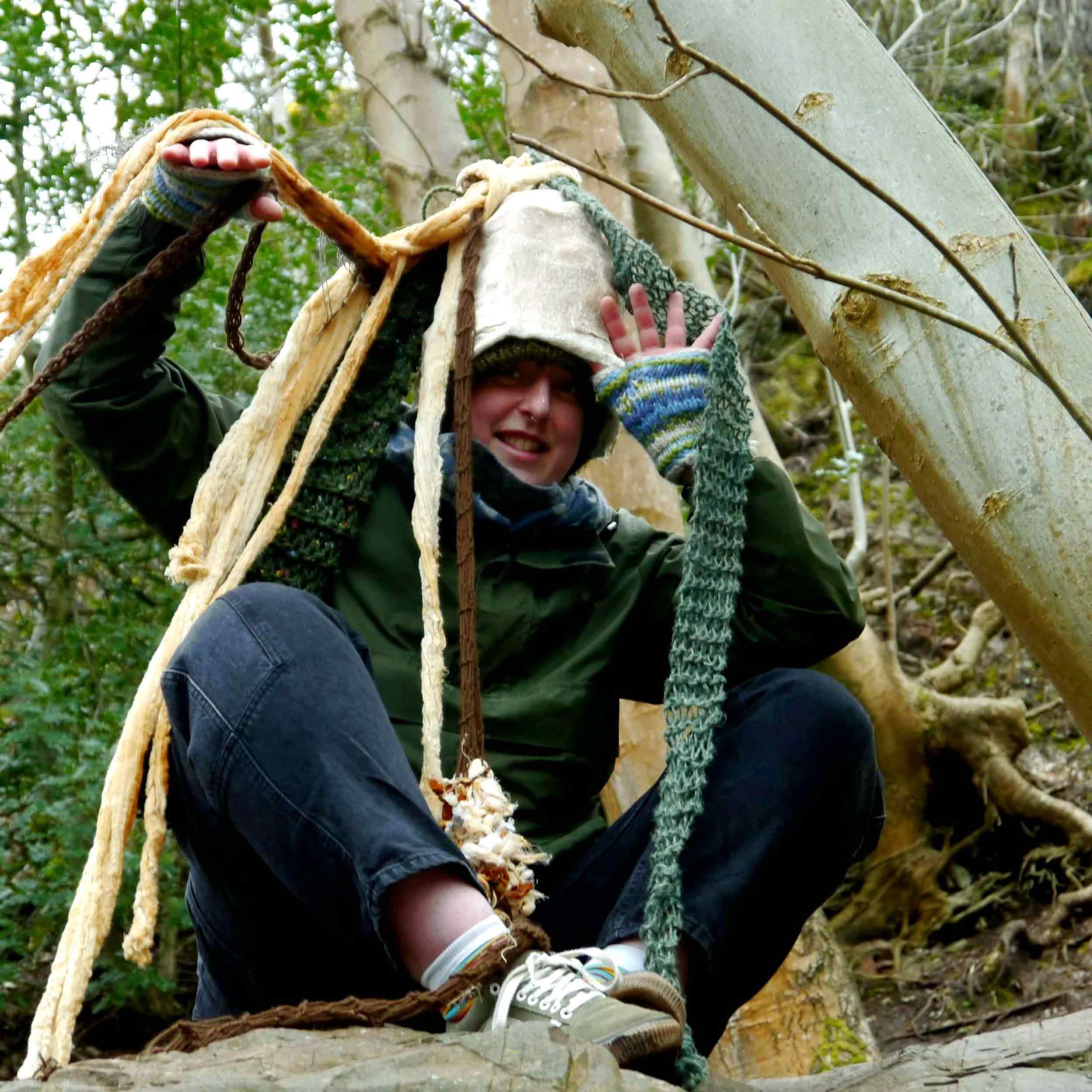 Artists wearing a modroc hat with knitted tendrils 