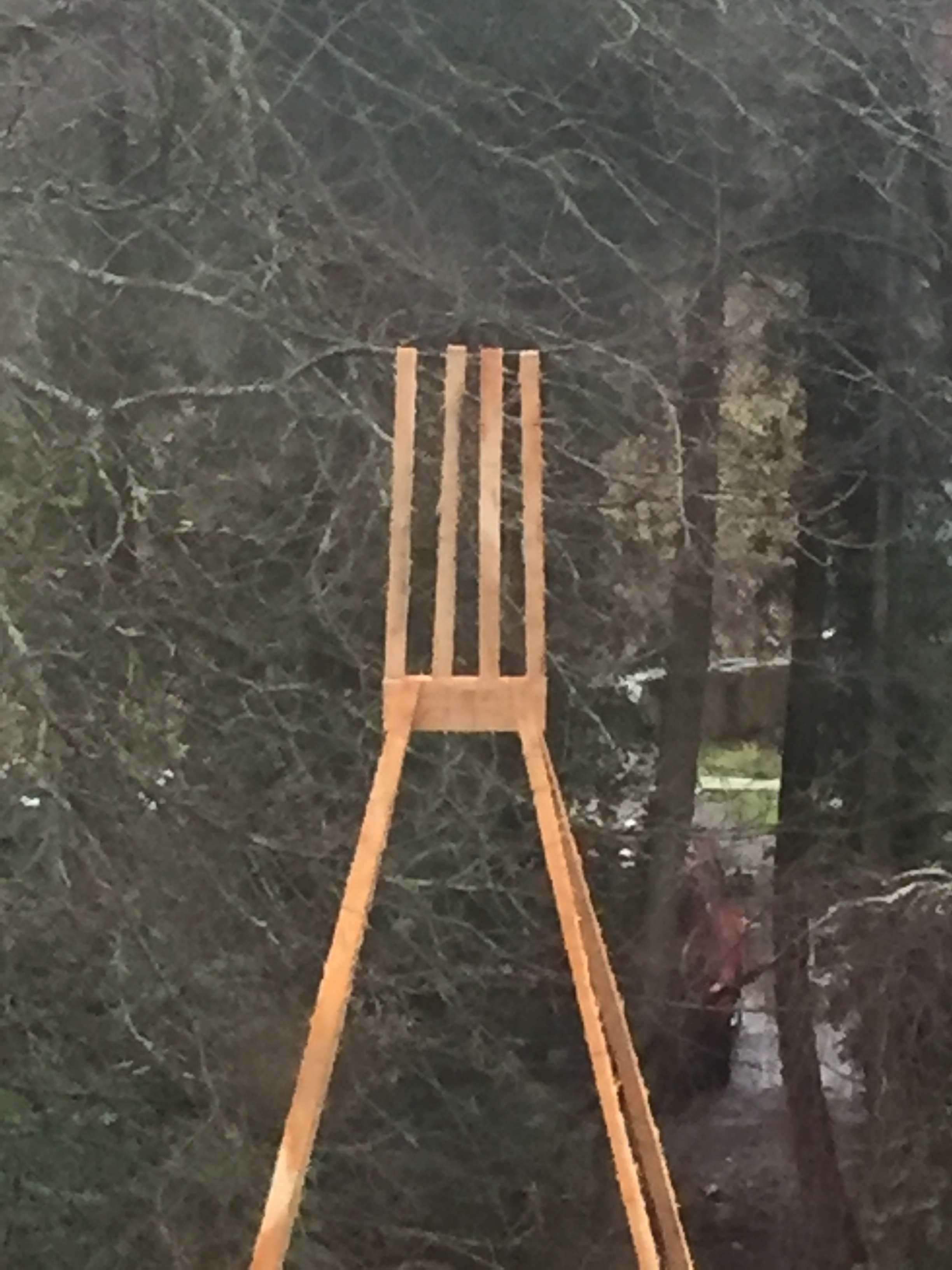 A tall wooden sculpture stood in a green field.
