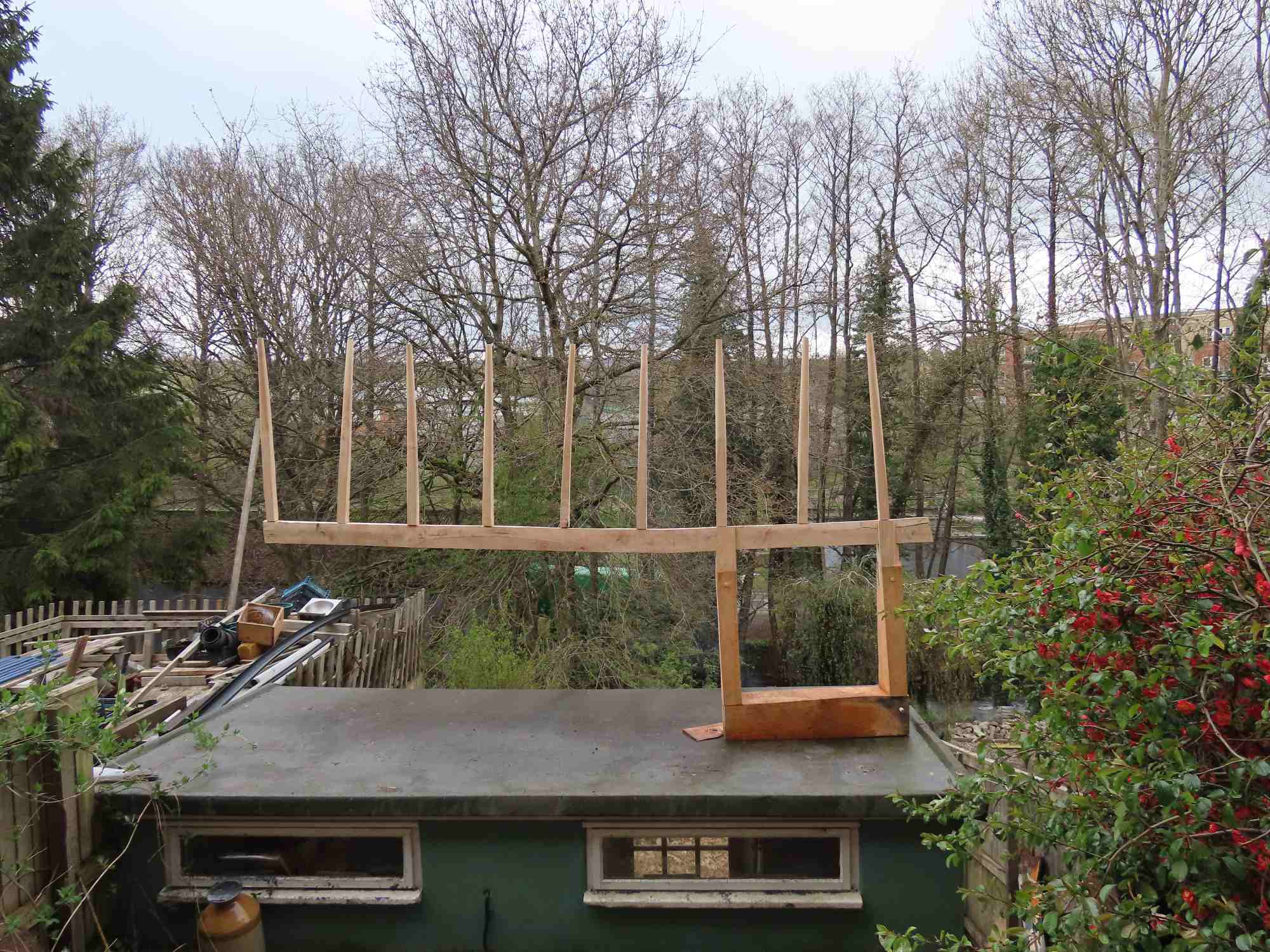 Uneven fence like sculpture a top a shed roof.
