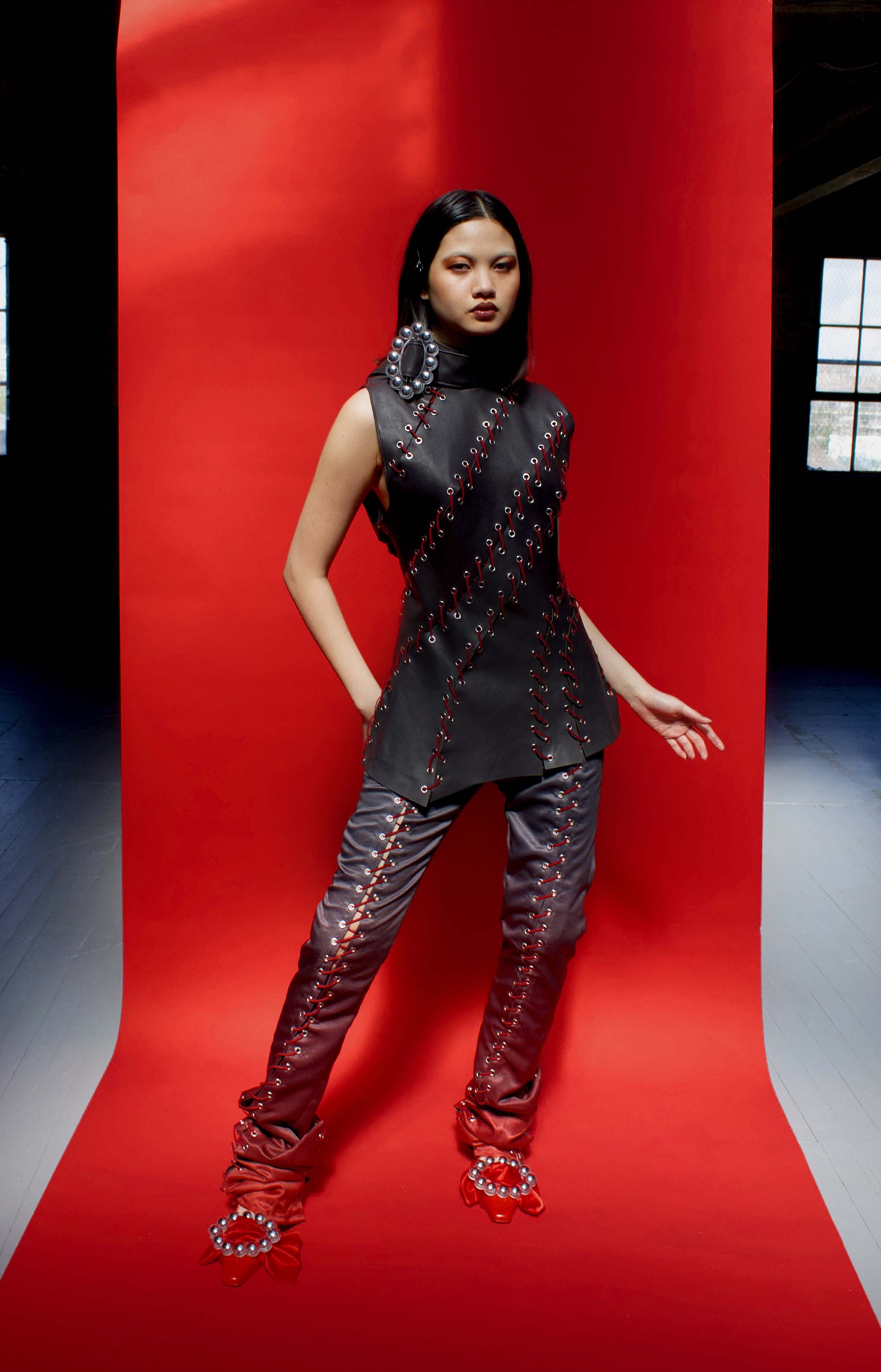model wears black laced leather top and black to red ombre trousers