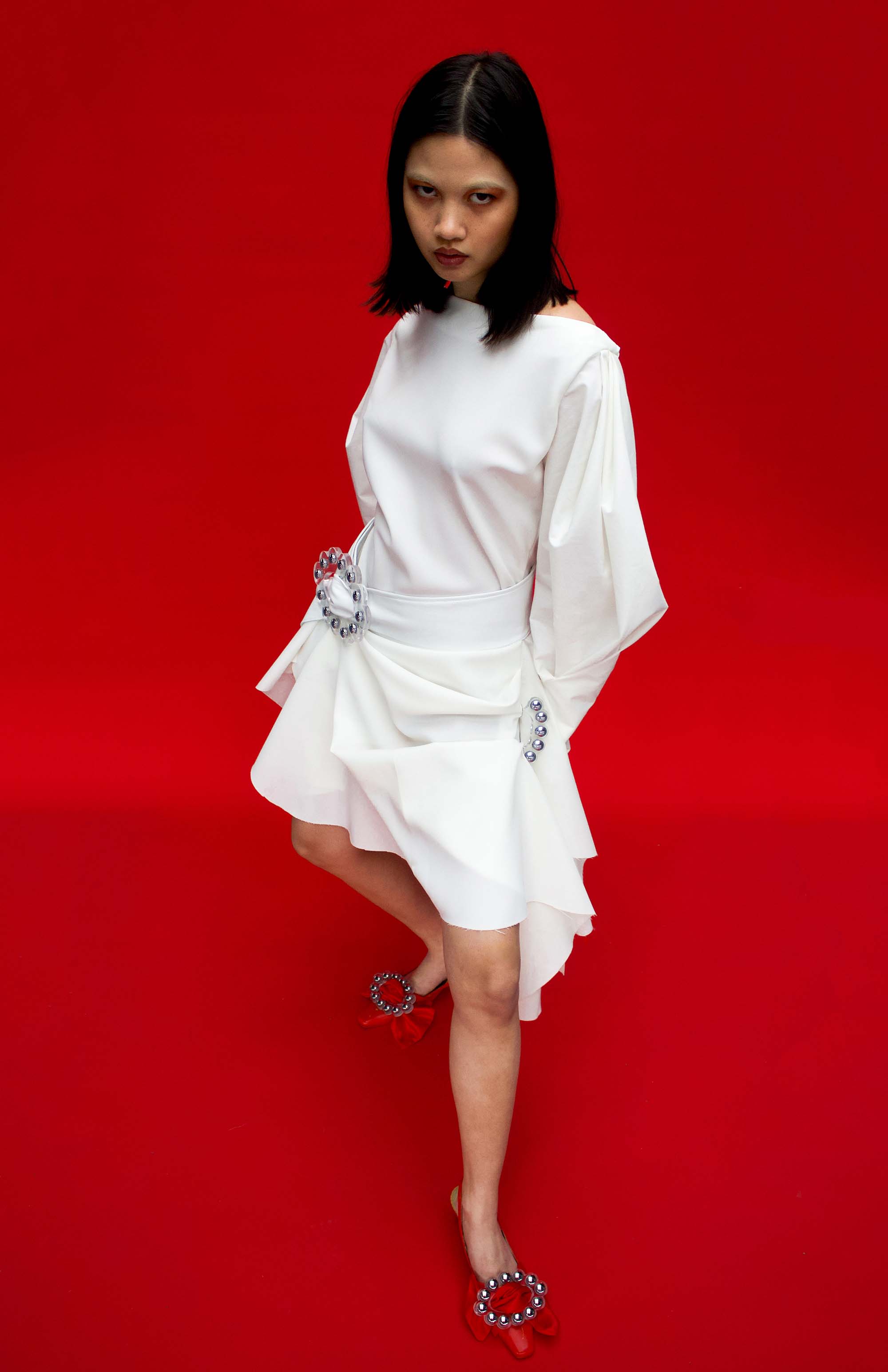 model wears white draped dress