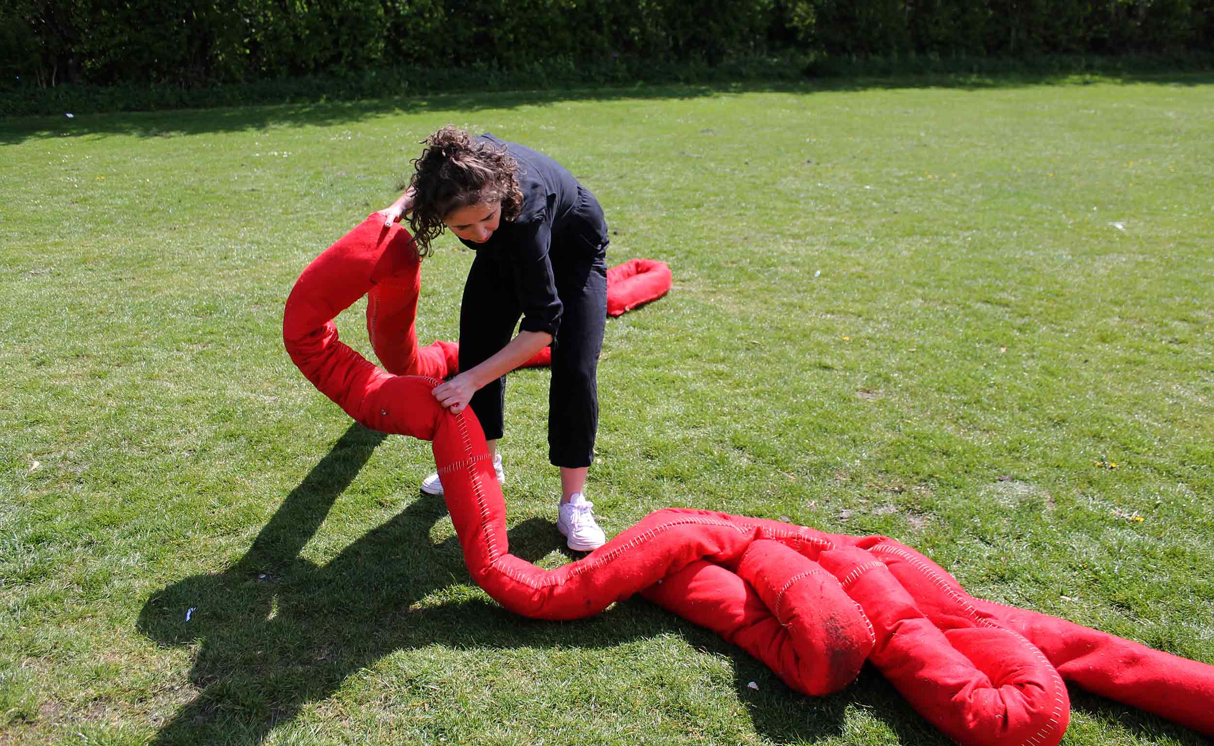 Image of Charlotte shaping red sculpture.