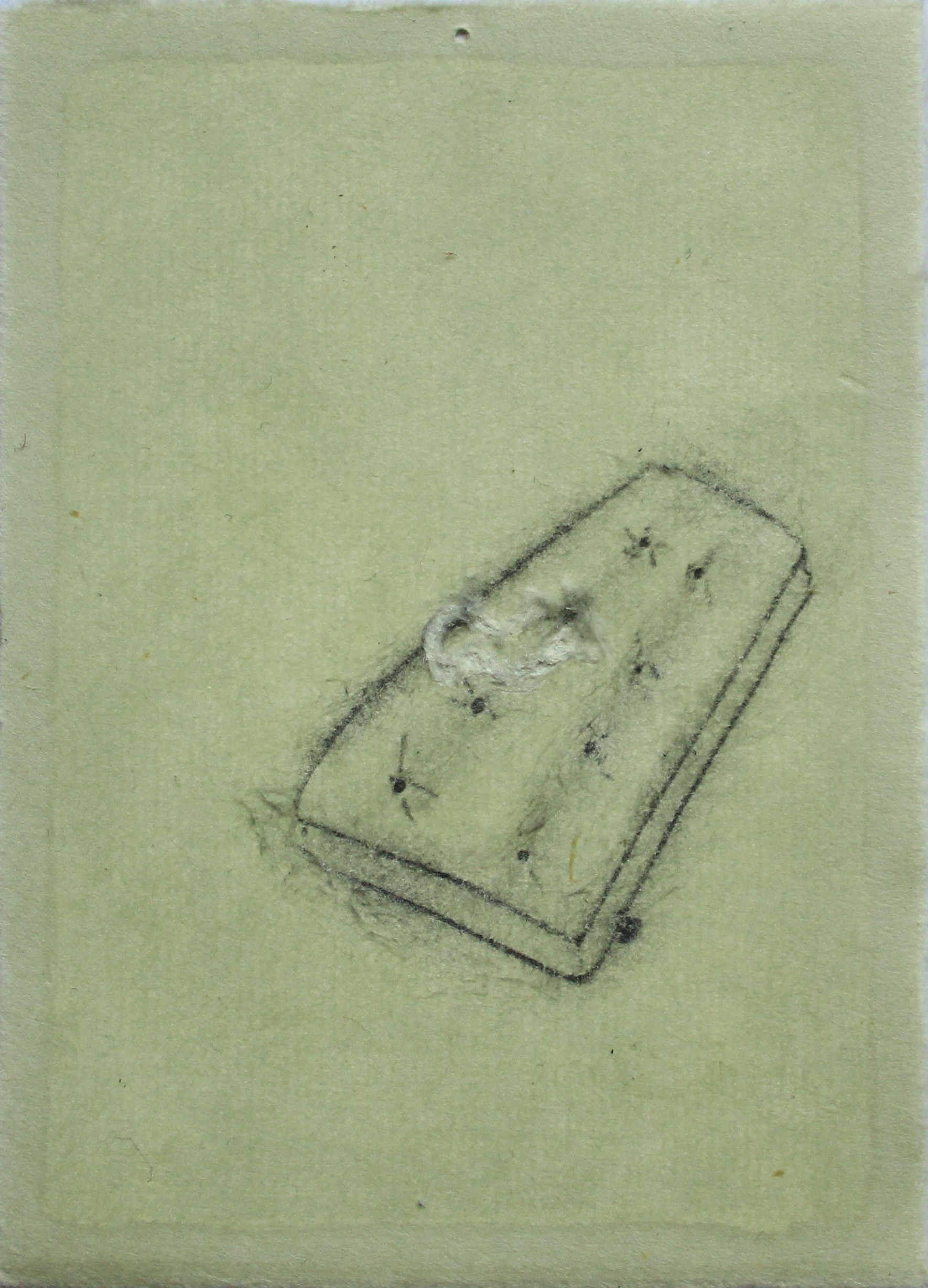 A drawing of a grapefruit skin is placed on a mattress, the bed is drawn with 2B pencil on washi paper, and the skin is white and scratched into the paper.
