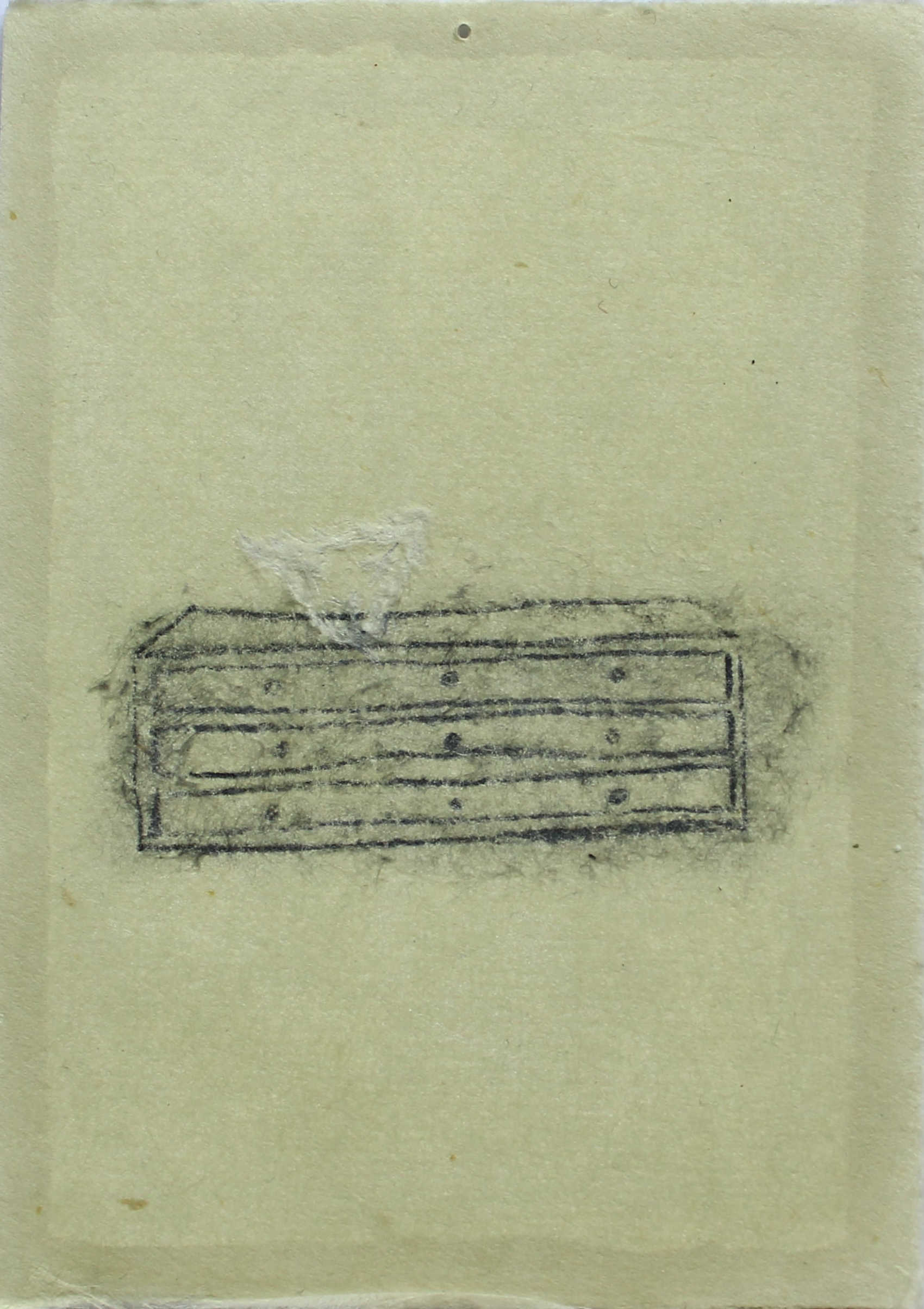 A drawing of a passion fruit skin is placed on a chest of drawers, the drawer is drawn with 2B pencil on washi paper, and the skin is white and scratched into the paper.