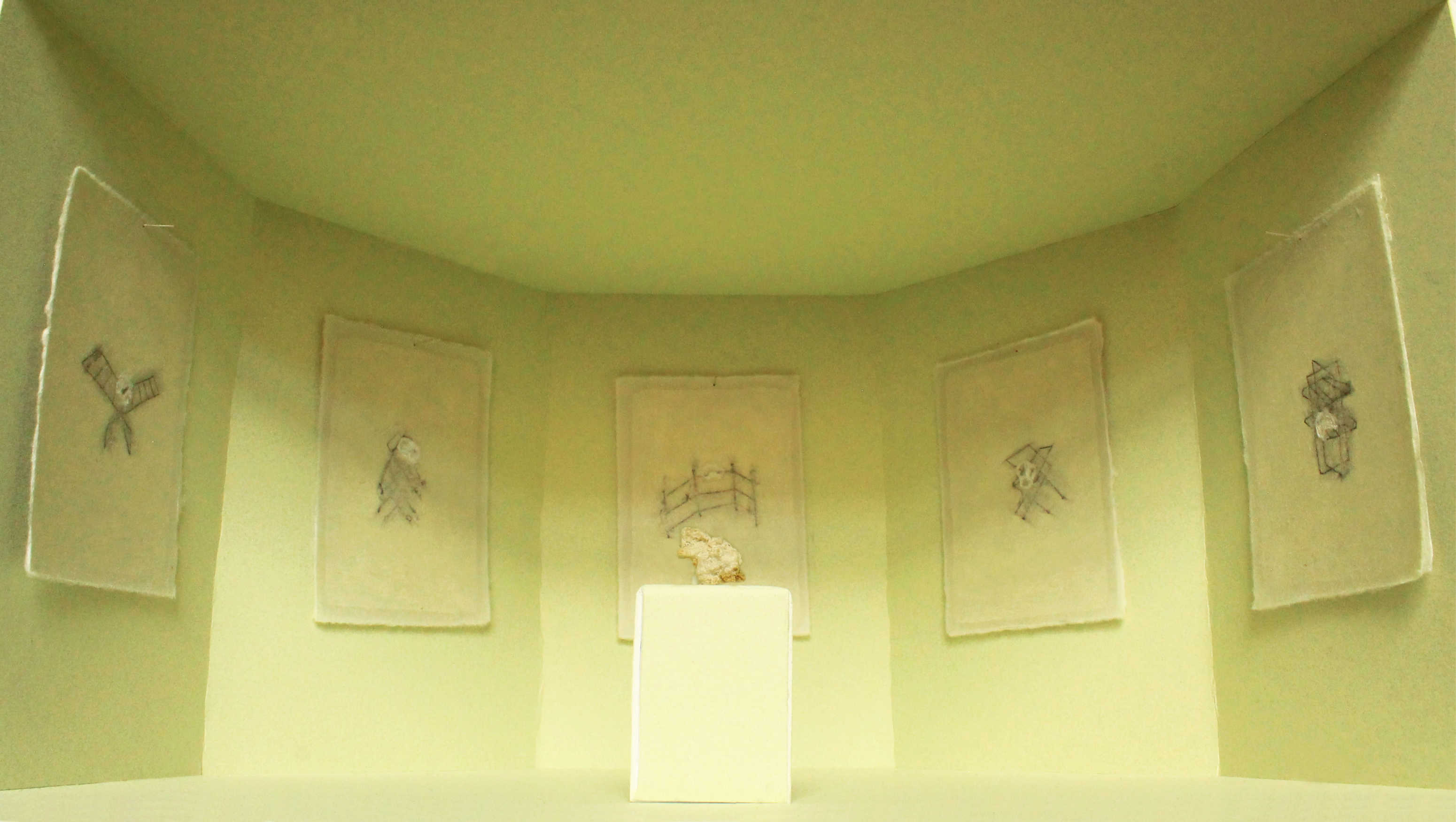 A pale potato starch sculpture is sat on a green plinth, surrounded by drawings on green washi paper installed in a green room. 