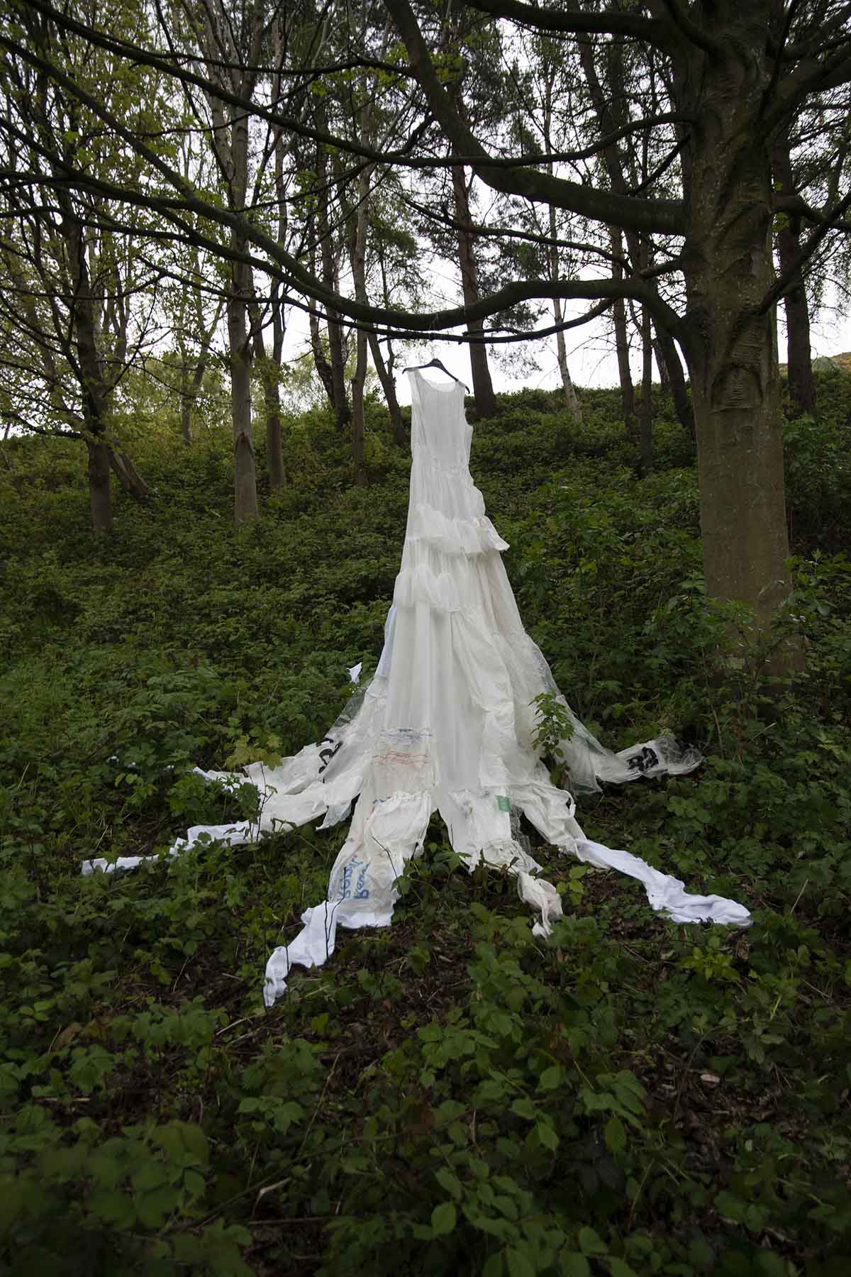 A long white dress hanging from a tree