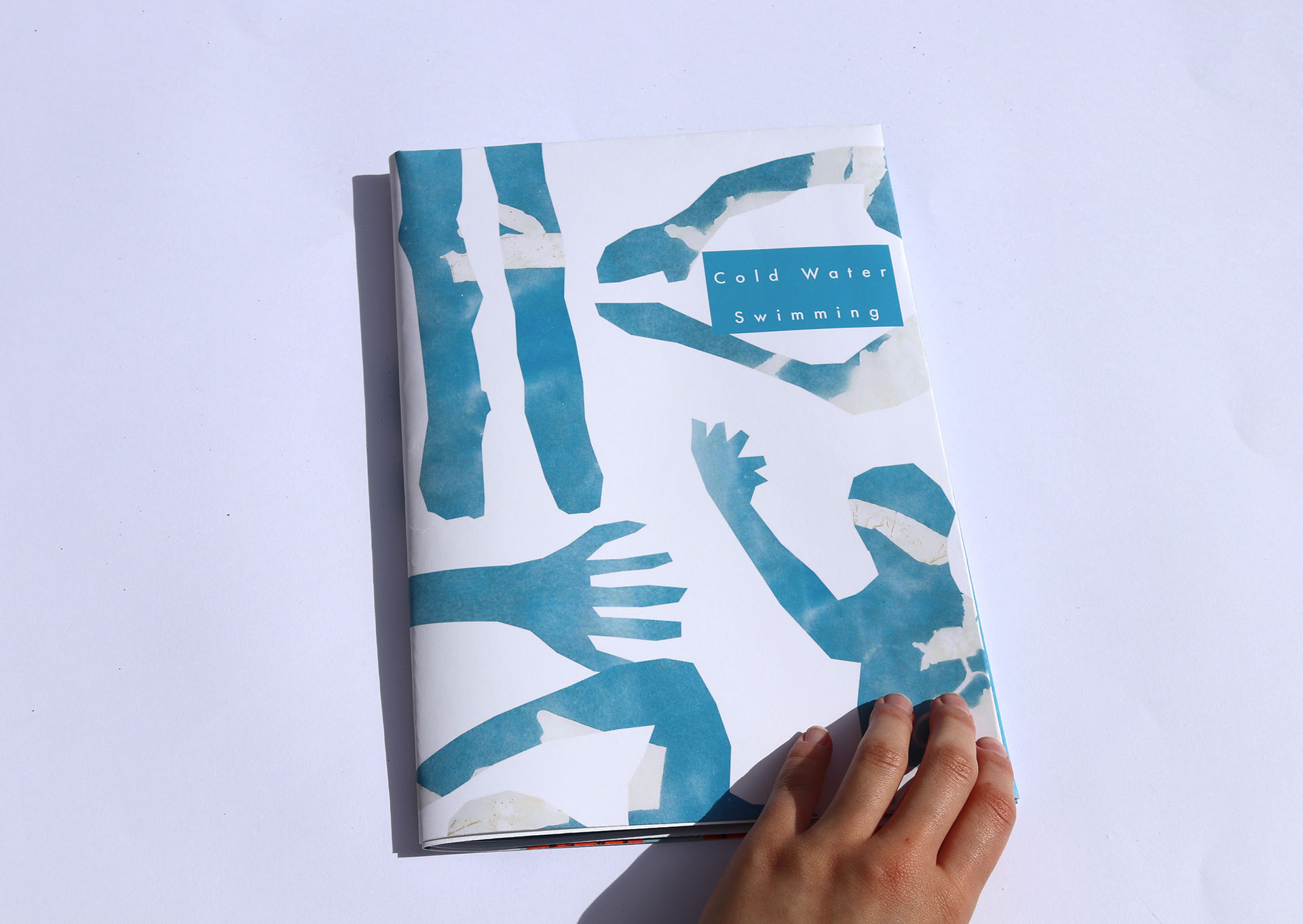 Front cover of a fold out poster on Cold Water Swimming. Blue collaged swimming arms, legs and body shapes make up the cover.  