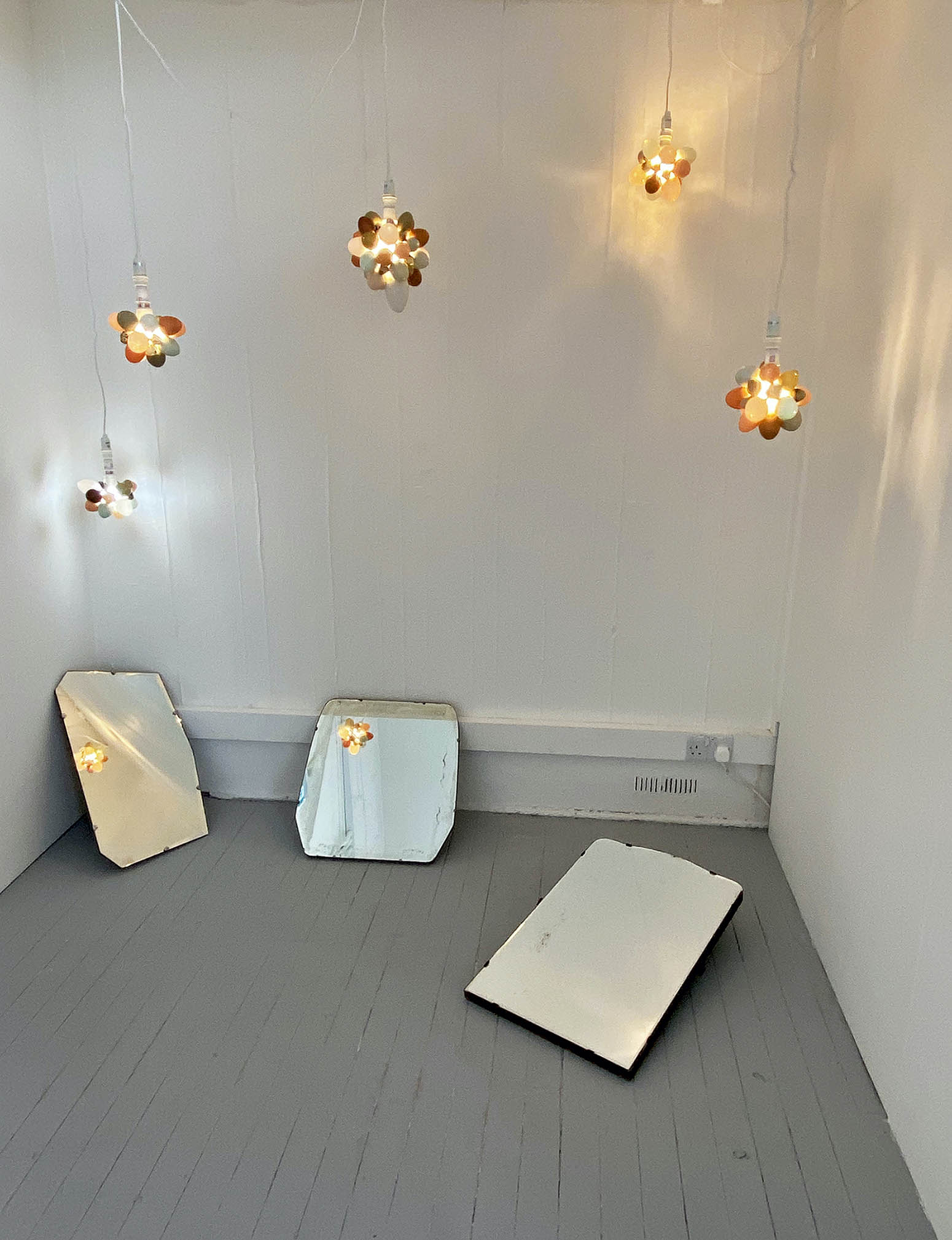 Illuminated Shells suspended over 2 antique mirrors