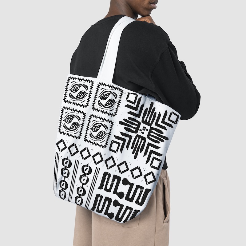 Woman holding a bag with black, symbol patterns printed on