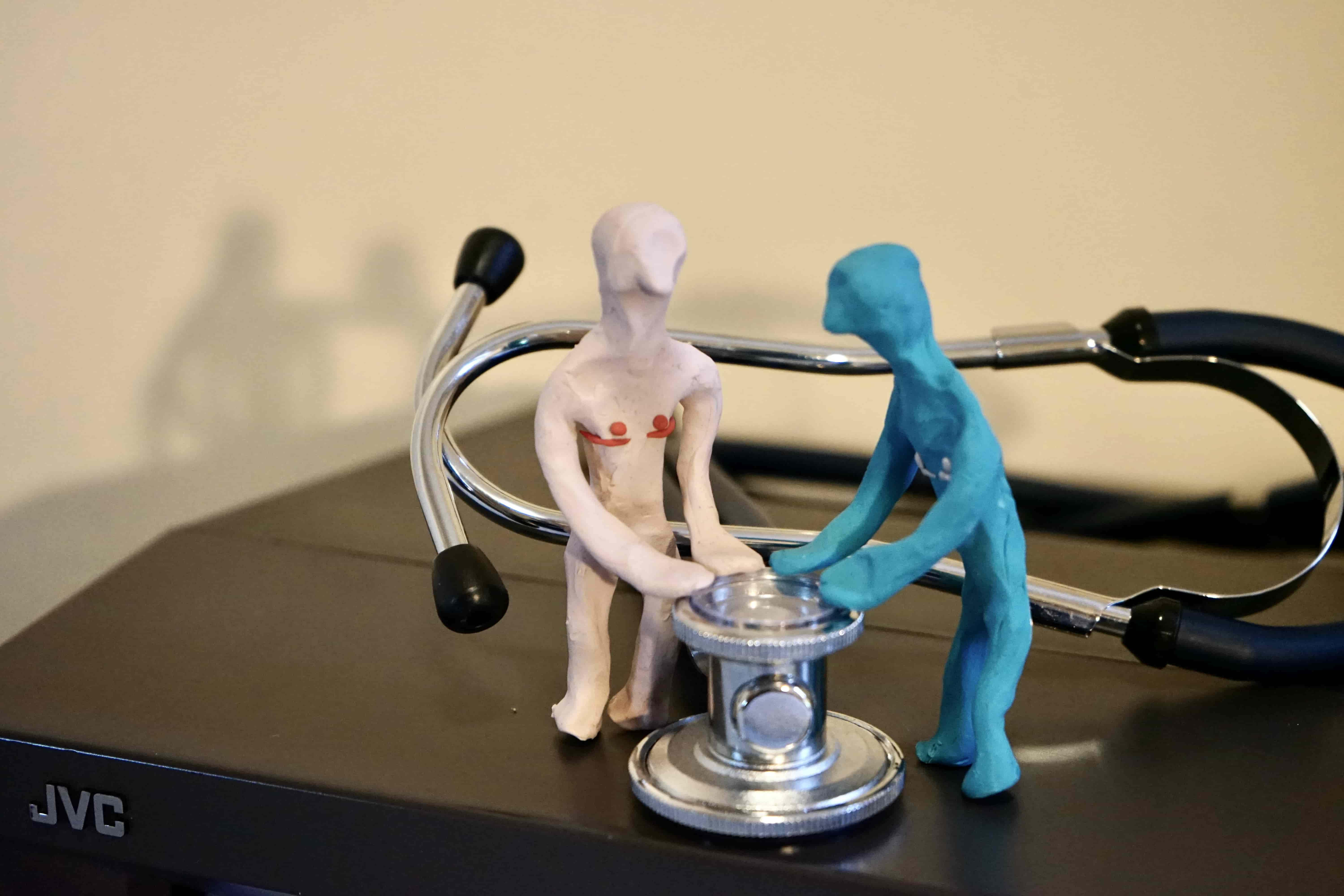 2 plasticine figures standing at stethoscope 