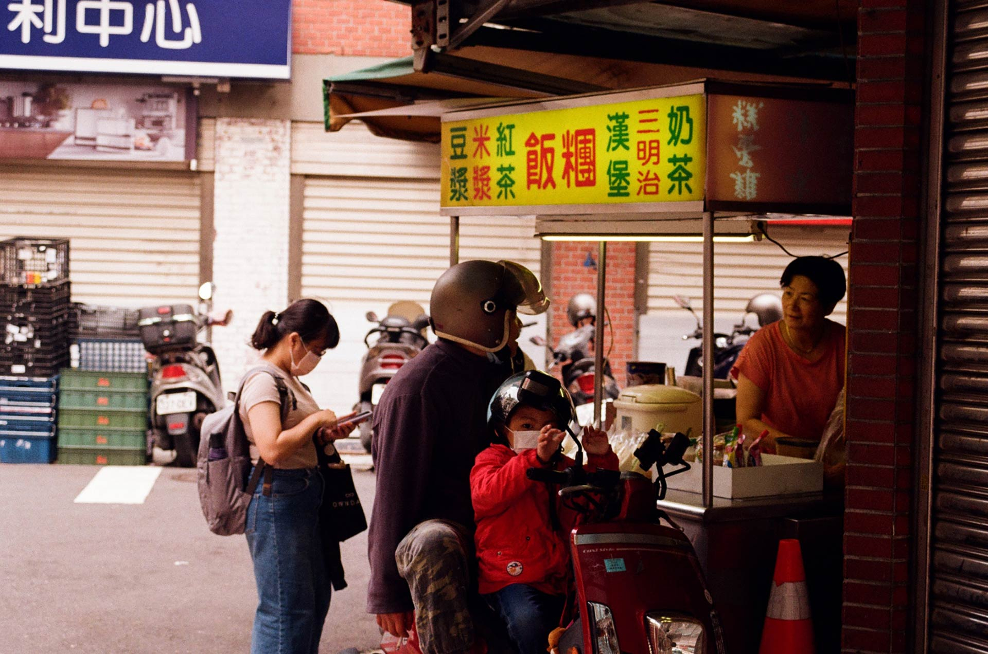 Line for small stand, kid on scooter waiting as father takes order