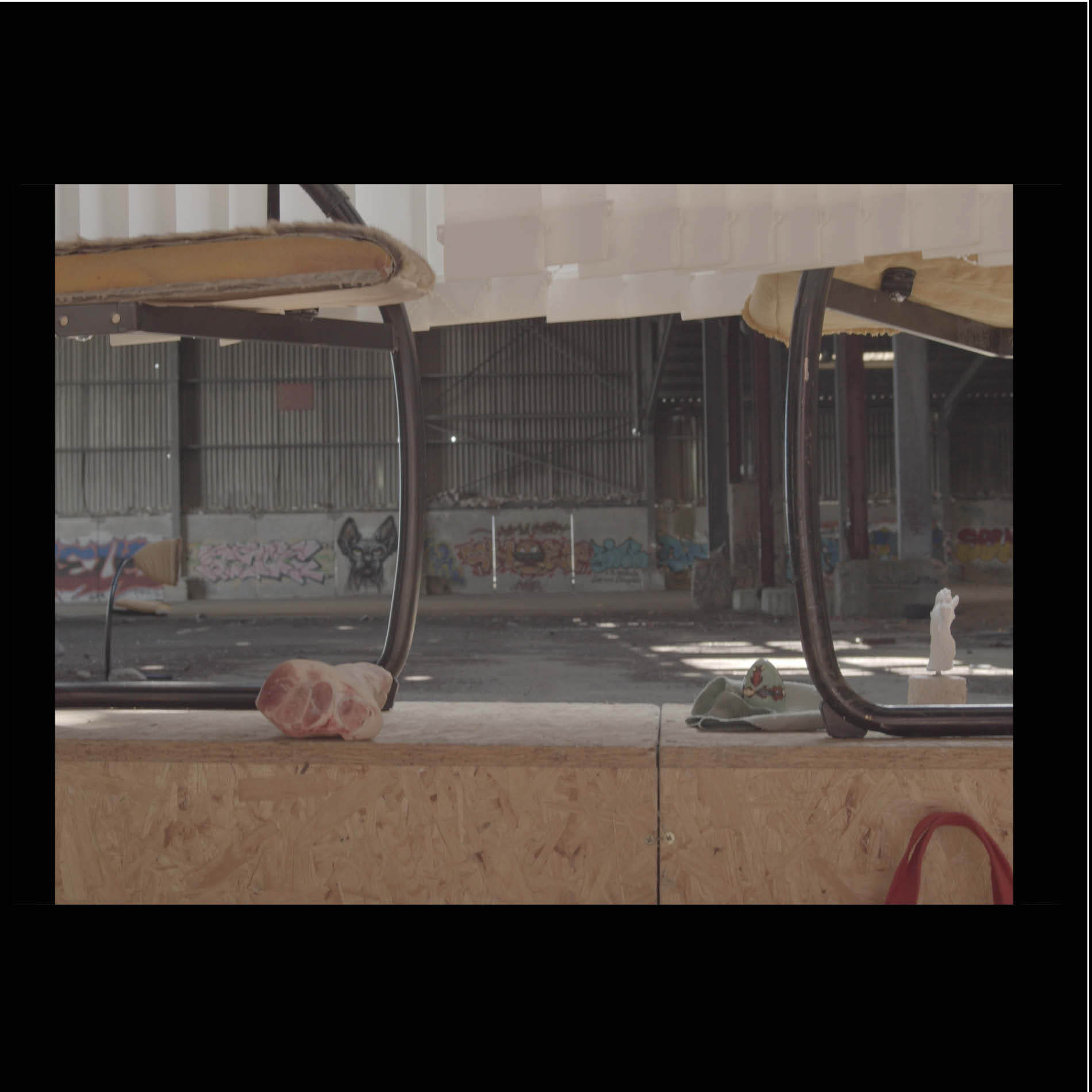L'usine MF. Still of a filmed scenography, France, April 2021. Egg yolk, waiting room chair cut in half, fur.