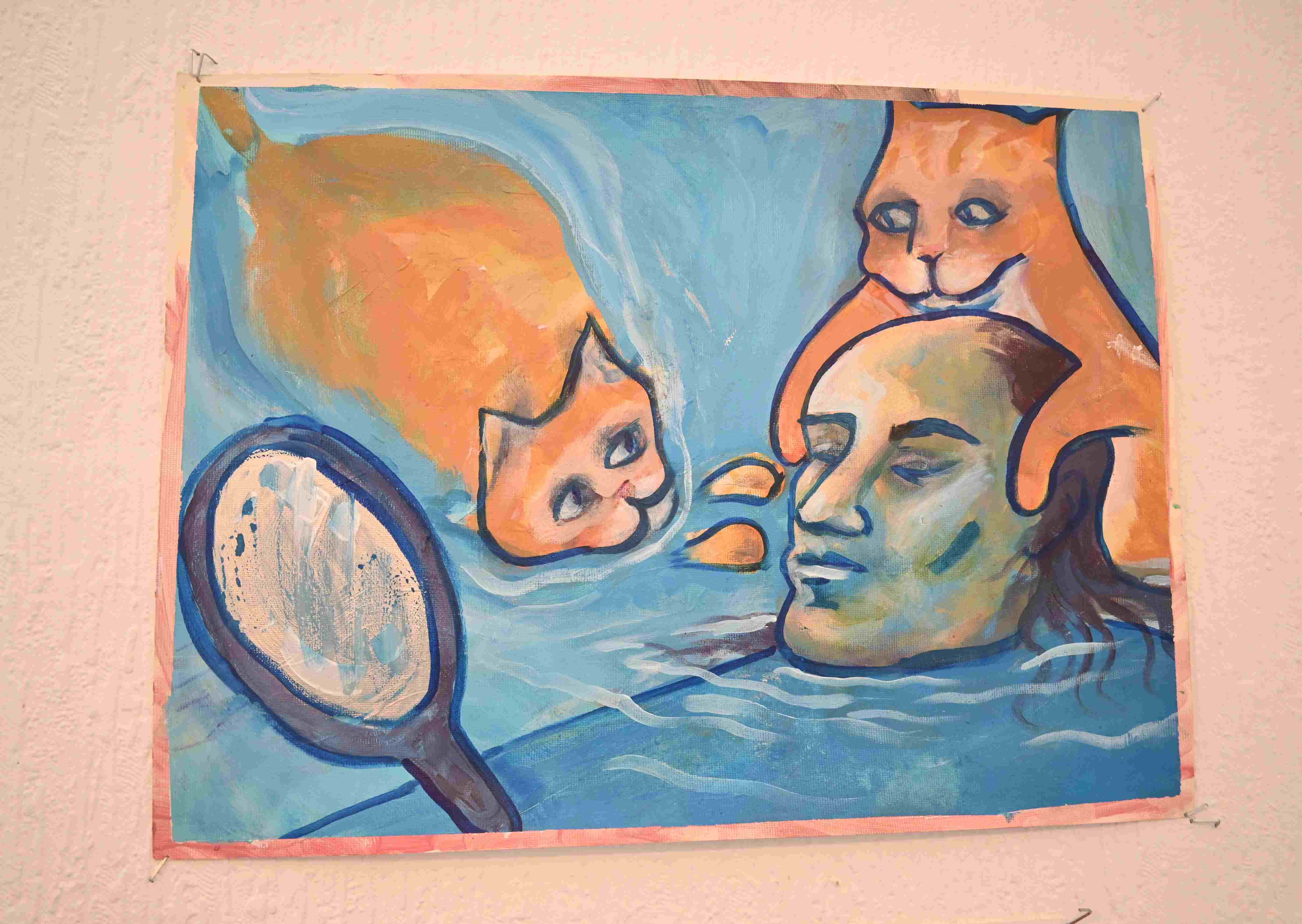 2 cats swimming up to a baulding man in an ocean holding a mirror