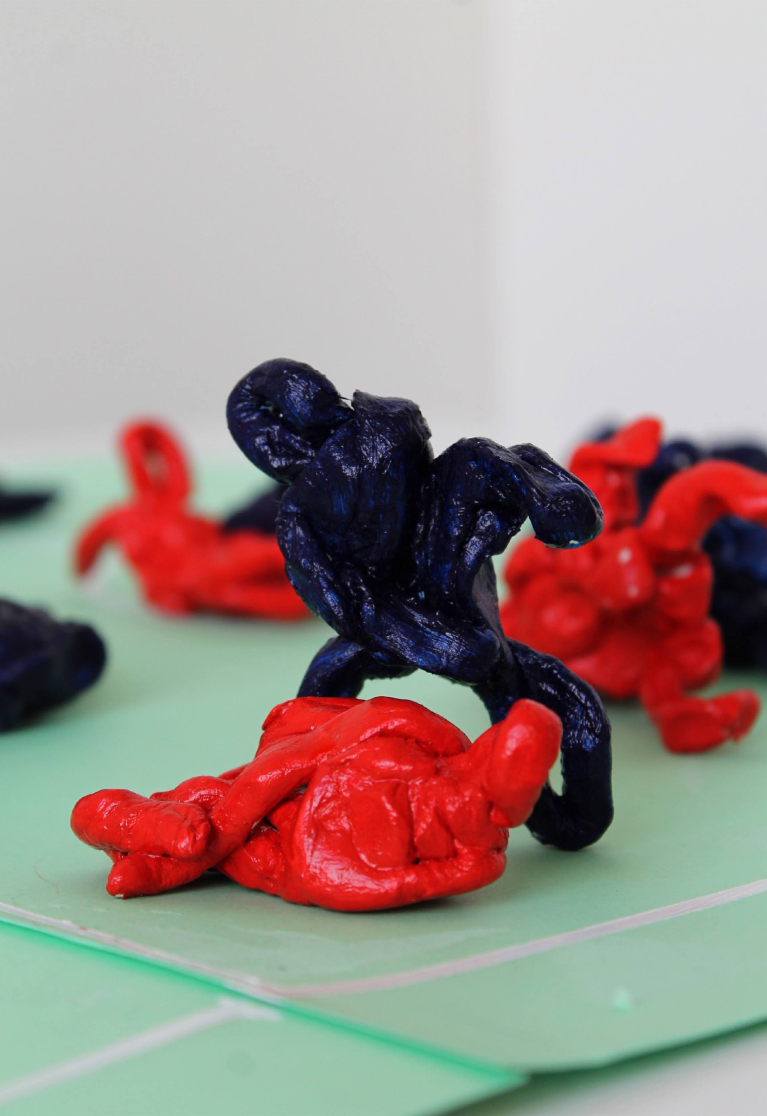Detail image of small blue and red figures on model football pitch. 