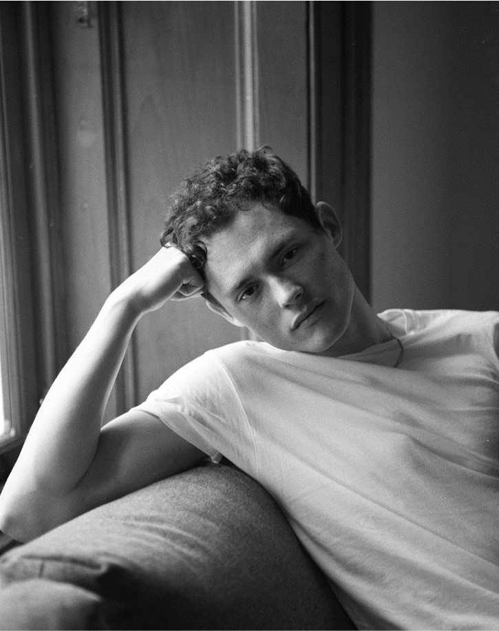 Portrait of a young man leaning on his arm in black and white