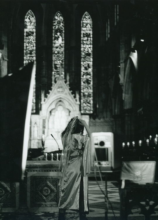 Alliyah ties hair back, stood in the cathedral 