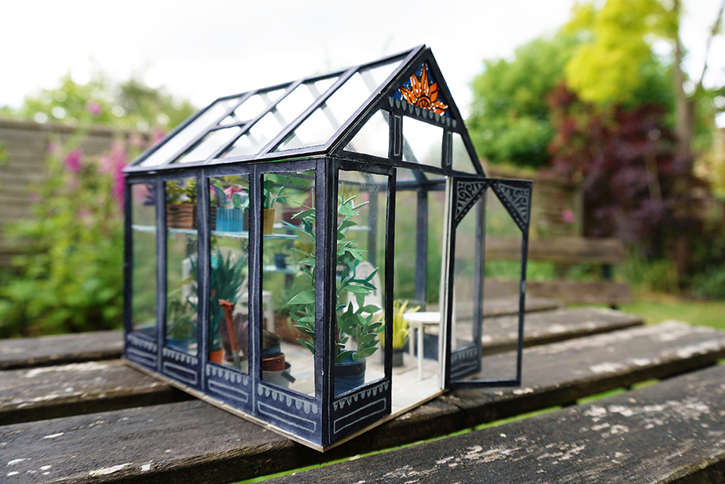 Miniature model greenhouse, made out of paper and perspex