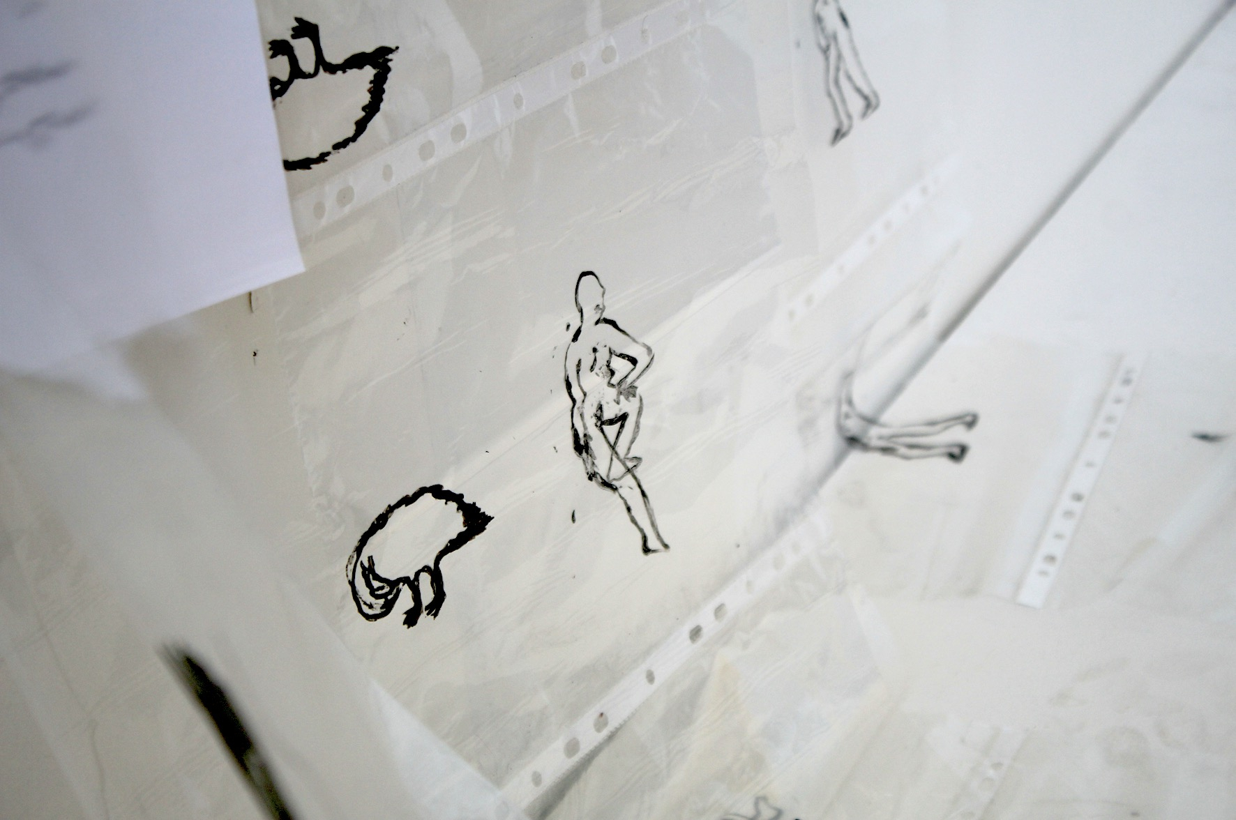 close up of an ink drawing of a lady on a sheet of acetate moving in a breeze 