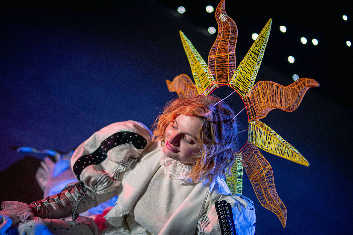 Poppet sitting on the floor eyes down.