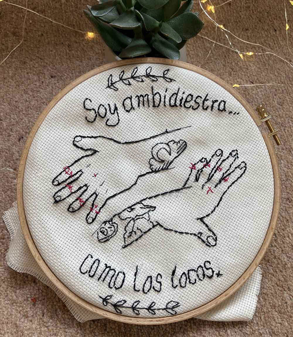 Embroidery illustration with a text in Spanish which translates "I'm ambidextrous, as the crazy ones". 