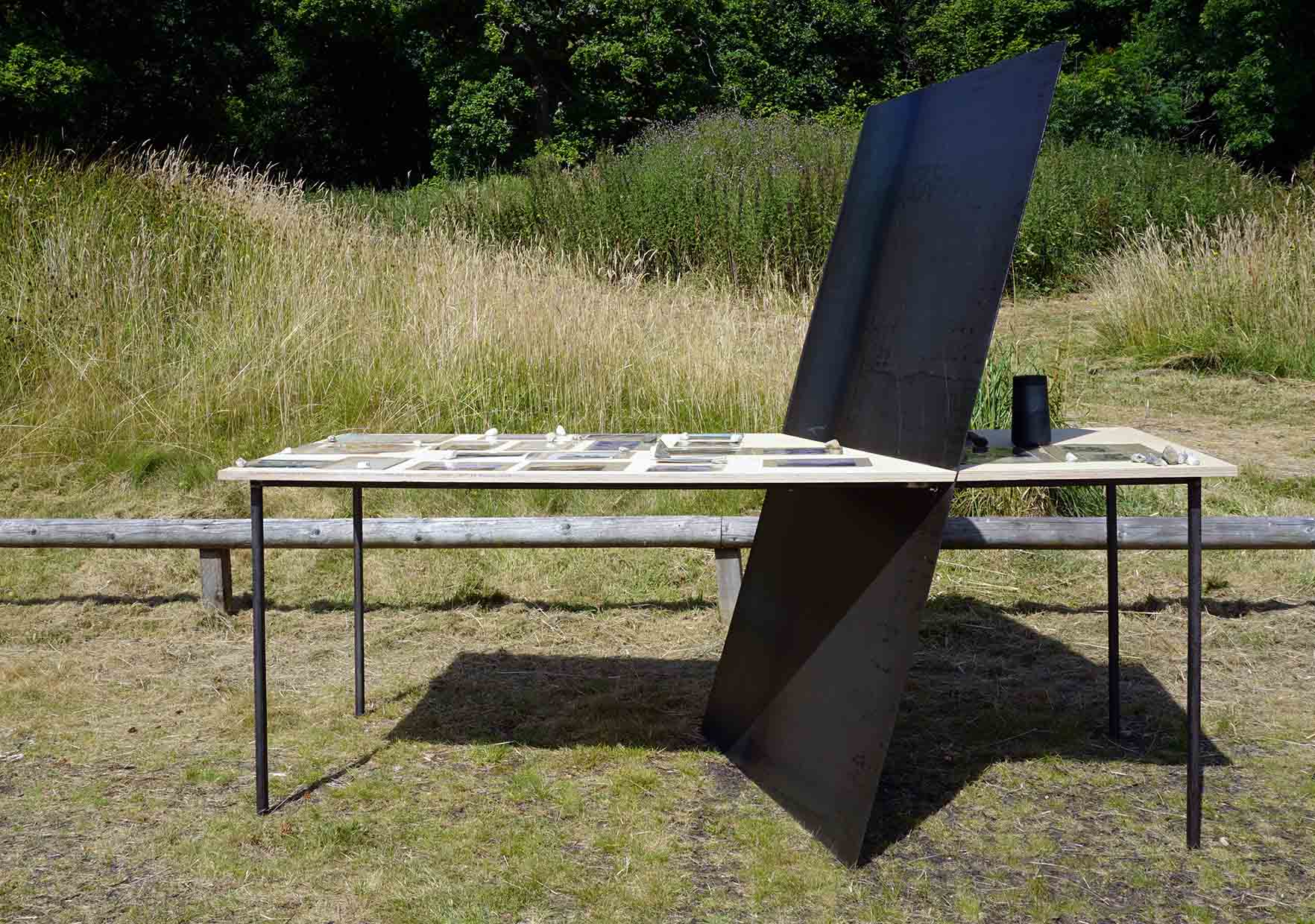 a clear side view of the table again it shows how the large steel sheet is placed and interacts with the table top 