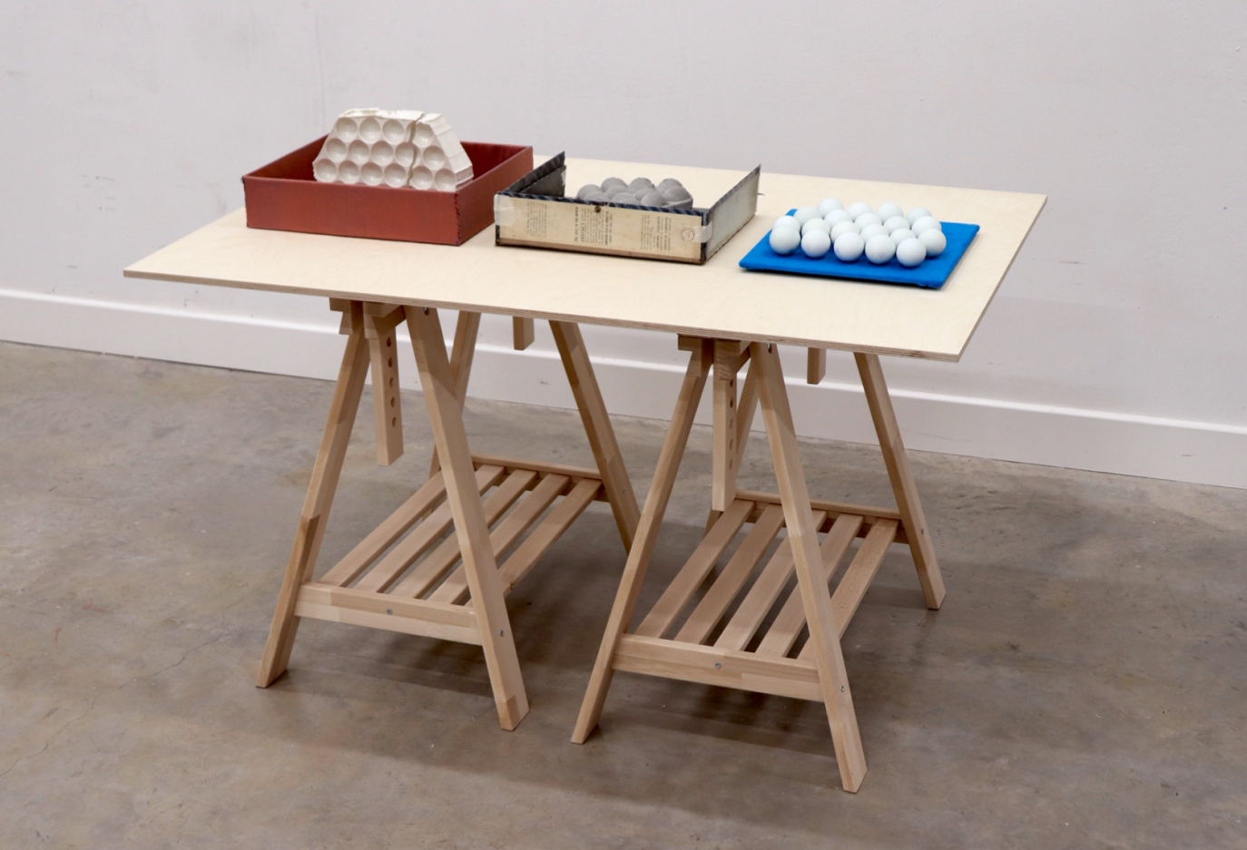 A table with three boxes on. Each box contains an iteration of an Estonian egg bag. 