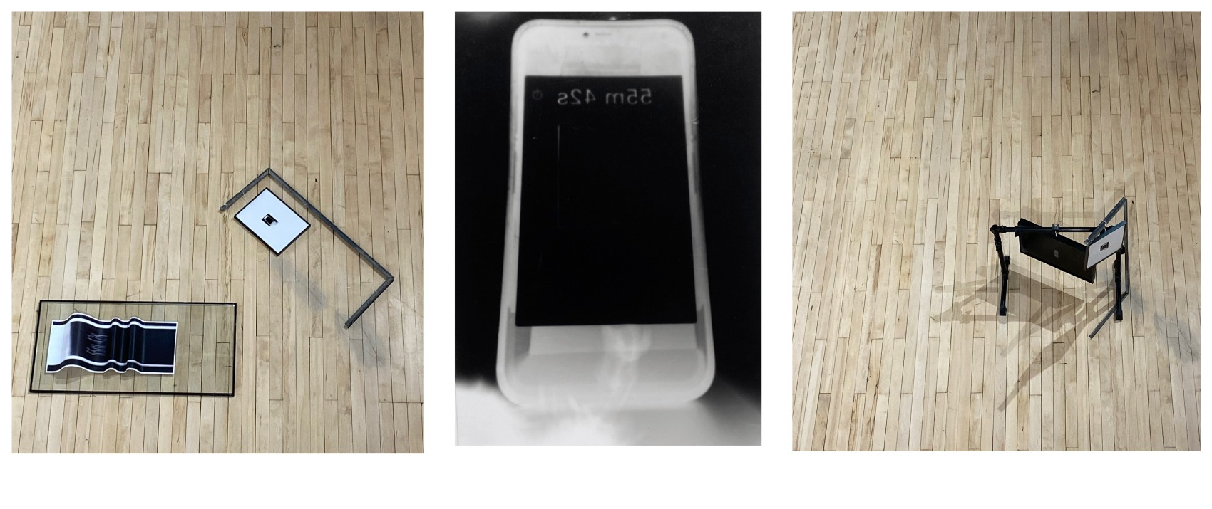 This image displays three different photographs.  The left and right hand side image display variations of the work RESIDUES OF CUSTOMISATION taken from an aerial perspective. In these images, linear structures are positioned on a wooden floor. The black and white photograph in the middle of series displays a silhouette of a mobile phone. On the screen, the sequence 55m 42s can be faintly read. 