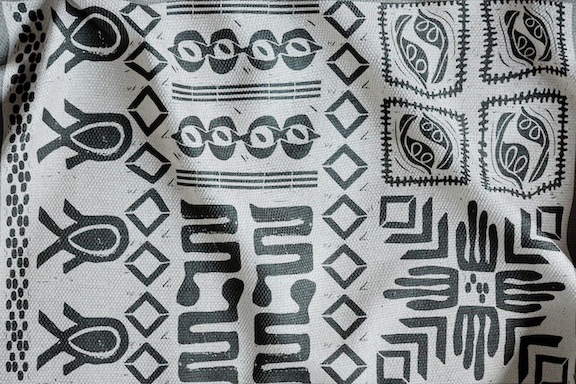 Close up image of hand-printed symbols and patterns on unrefined cloth.